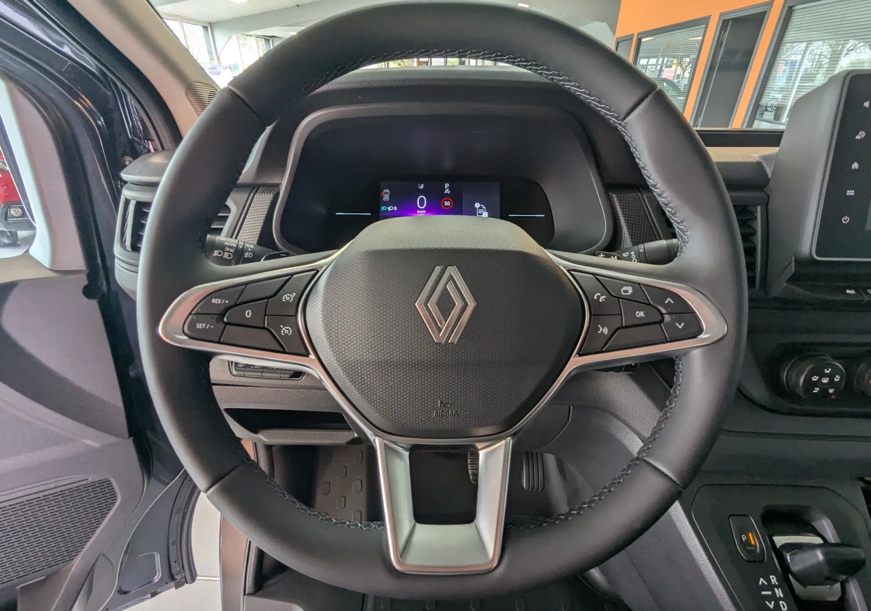 Vue rapprochée du volant noir du Renault Trafic Cabine Approfondie 2025 avec tableau de bord numérique et commandes intégrées.