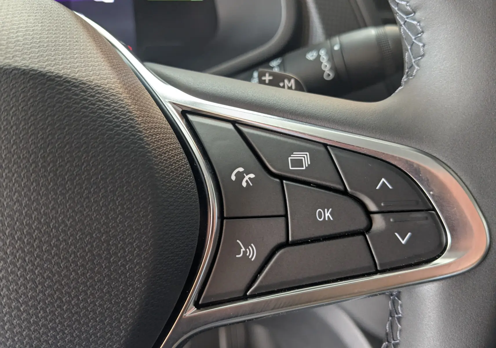 Gros plan sur les commandes multifonctions au volant du Renault Trafic Cabine Approfondie gris comète, version 2025.