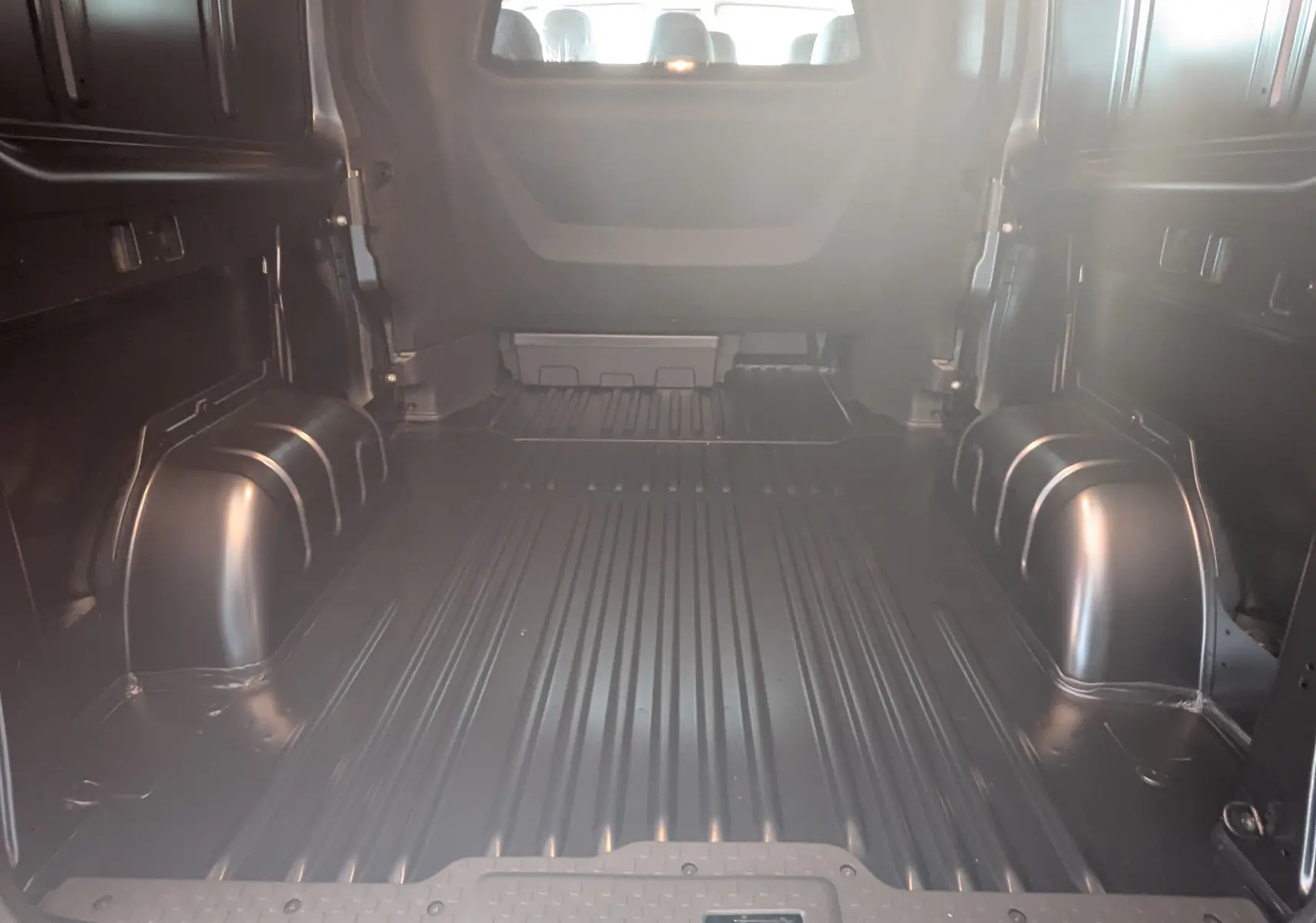 Vue intérieure de la zone de chargement noire du Renault Trafic Cabine Approfondie L2H1 2025, sans aménagement visible.