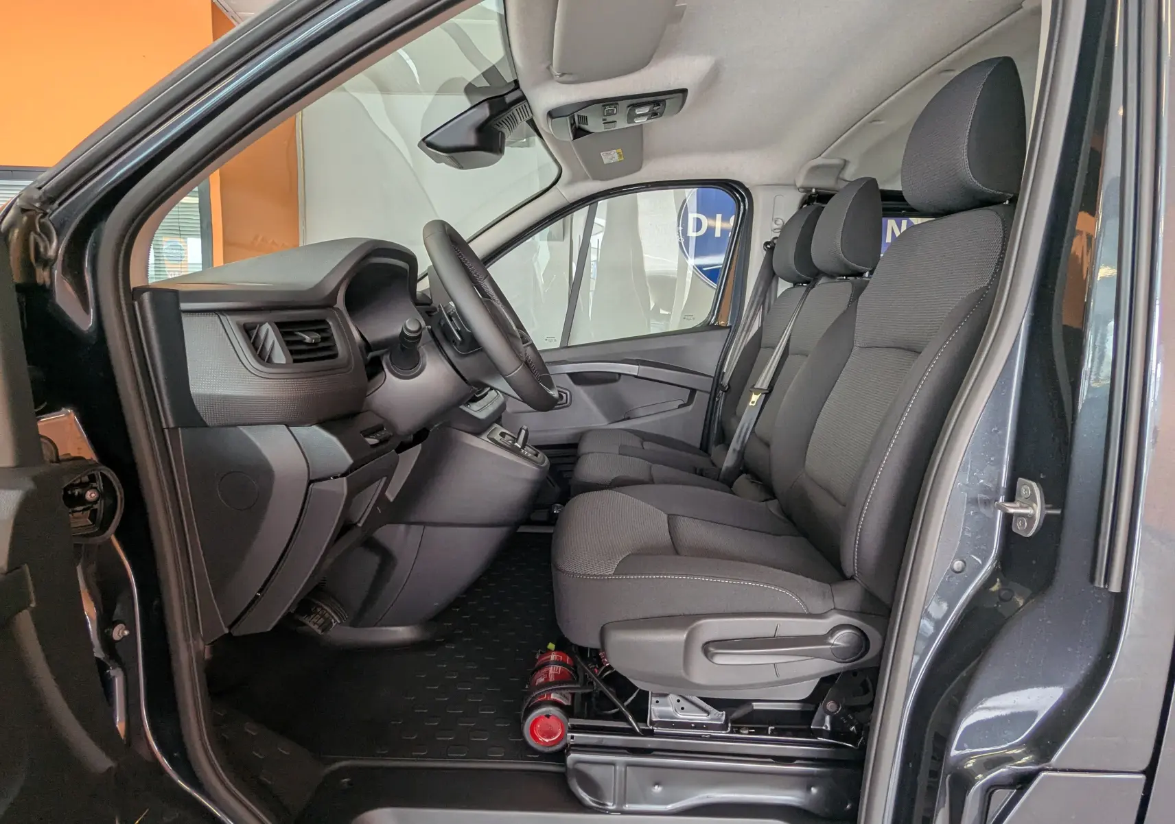 Vue intérieure côté conducteur du Renault Trafic Cabine Approfondie gris comète, montrant les sièges avant et le tableau de bord.