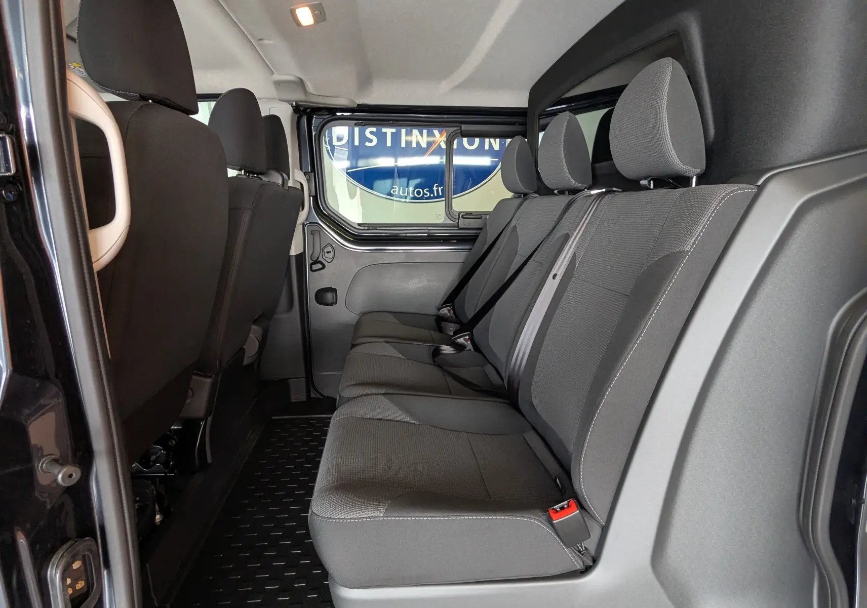 Vue latérale intérieure montrant la banquette arrière grise du Renault Trafic Cabine Approfondie L2H1 2025.