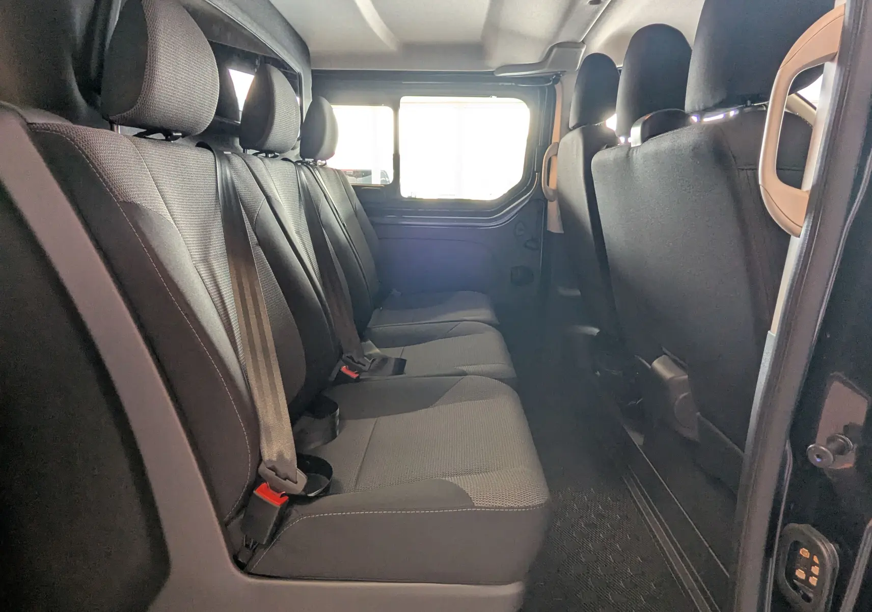 Vue intérieure latérale gauche montrant la banquette arrière noire du Renault Trafic Cabine Approfondie gris comète.
