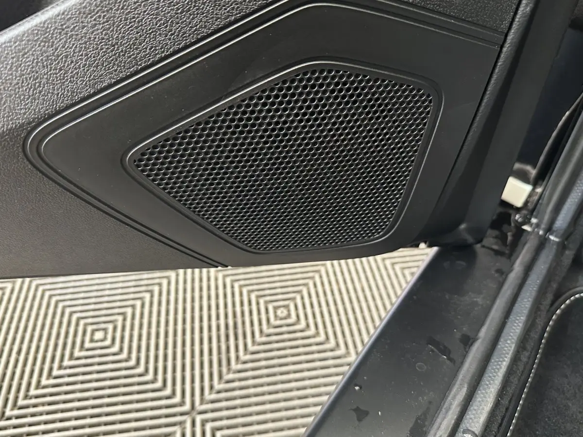 Gros plan sur l'enceinte intégrée à la porte intérieure côté conducteur d'un Aixam Ambition blanc 2026.