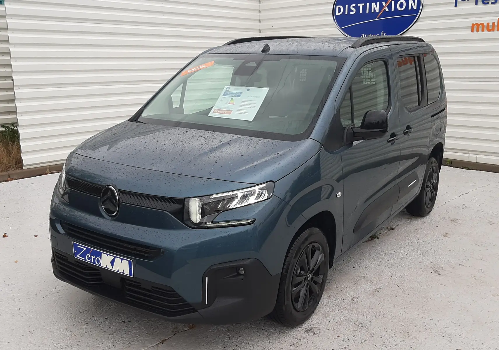 Vue 3/4 avant droite d'un Citroën Berlingo bleu Kiama 2026 avec jantes noires et calandre moderne.