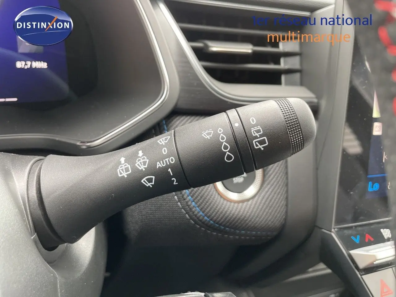 Gros plan sur la commande d’essuie-glace à gauche du volant dans l’habitacle noir du Renault Symbioz gris Cassiopée.