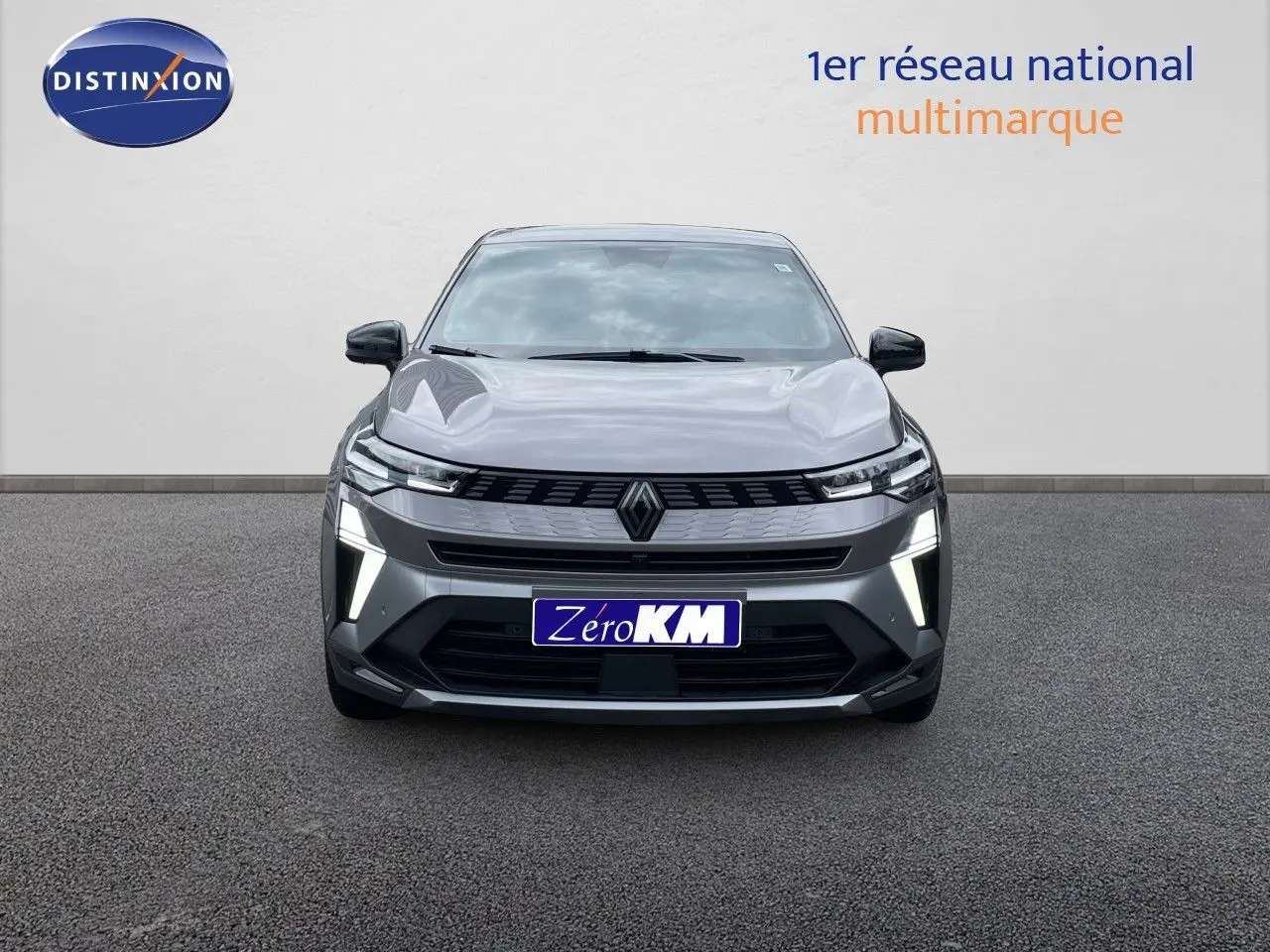 Vue frontale d'une Renault Symbioz gris cassiopée métal avec feux LED allumés sur fond neutre.