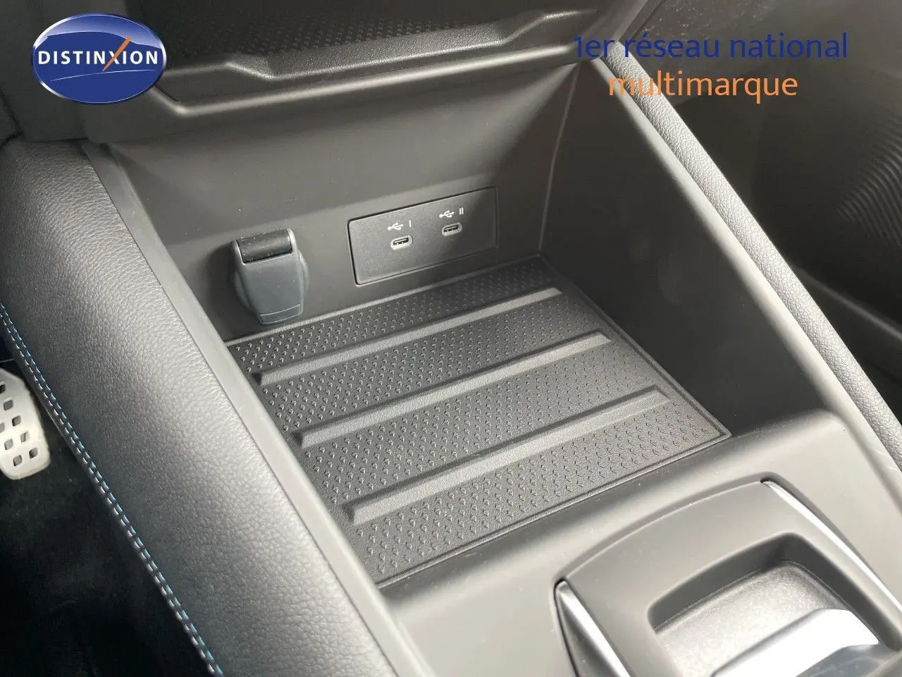 Gros plan sur la console centrale avec prise USB double et surface antidérapante du Renault Symbioz gris Cassiopée.