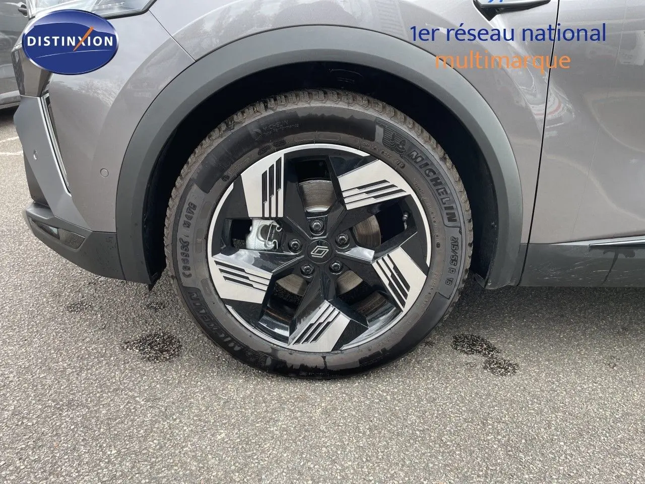 Gros plan sur la roue avant gauche du Renault Symbioz gris cassiopée métal, mettant en valeur la jante noire et argentée au design moderne.