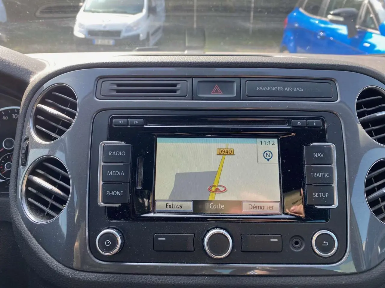 Vue rapprochée du tableau de bord du Volkswagen Tiguan blanc 2014 avec écran de navigation allumé.
