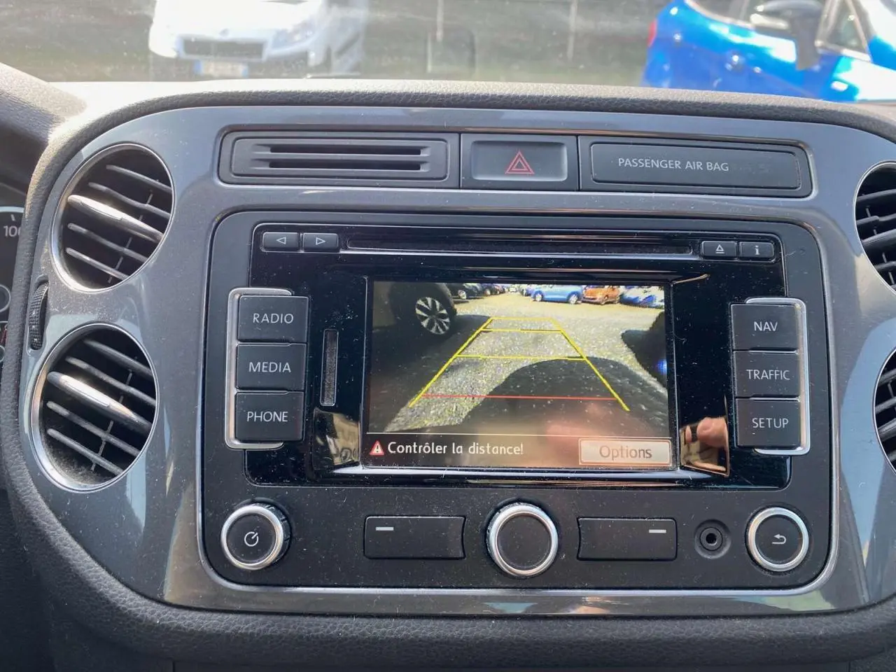 Vue rapprochée de l'écran central du Volkswagen Tiguan blanc 2014 affichant la caméra de recul en marche.