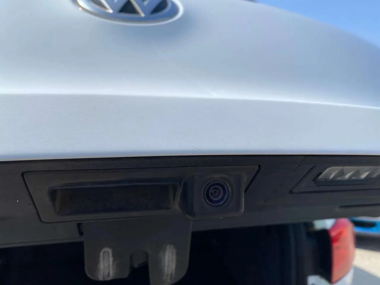 Gros plan sur la caméra de recul intégrée au hayon arrière blanc d’un Volkswagen Tiguan 2014.