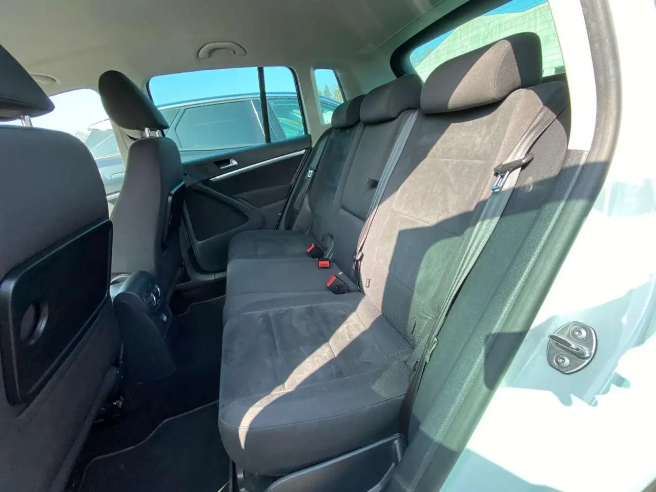 Vue intérieure côté droit montrant les sièges arrière noirs du Volkswagen Tiguan blanc de 2014.