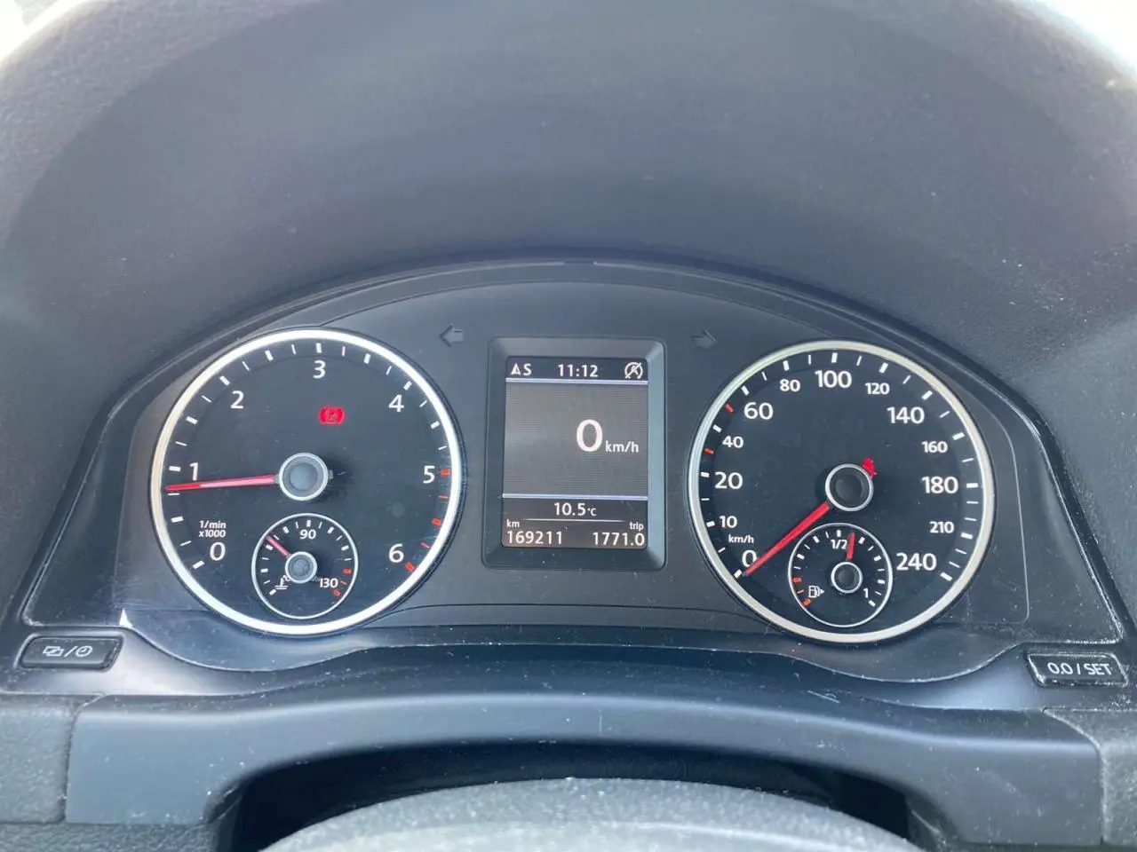 Vue rapprochée du tableau de bord du Volkswagen Tiguan blanc, affichant compte-tours, vitesse et écran multifonction.