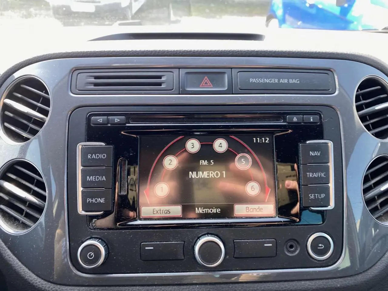 Vue rapprochée de l'écran multimédia central du Volkswagen Tiguan 2014 avec commandes radio et navigation visibles.