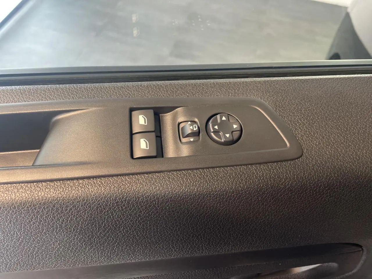 Commande des vitres et réglage des rétroviseurs sur la porte intérieure côté conducteur d'un Opel Vivaro noir carbone 2025.