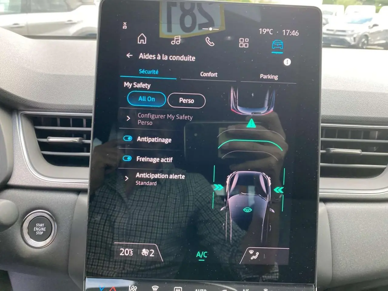 Écran tactile central affichant les aides à la conduite dans l'habitacle du Renault Captur gris Cassiopée avec toit noir.