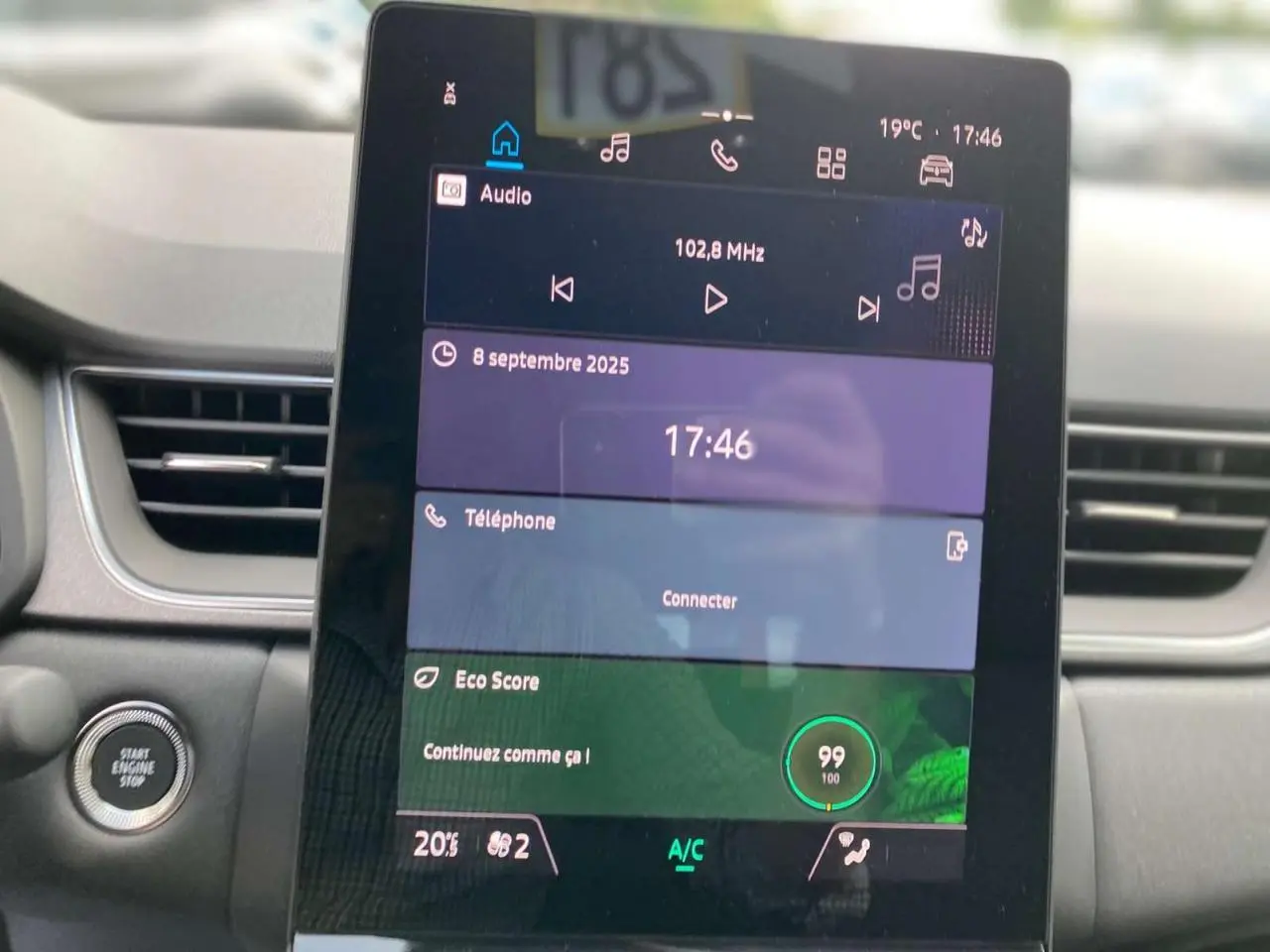 Écran tactile central du tableau de bord du Renault Captur 2025 affichant radio, téléphone et score Eco.