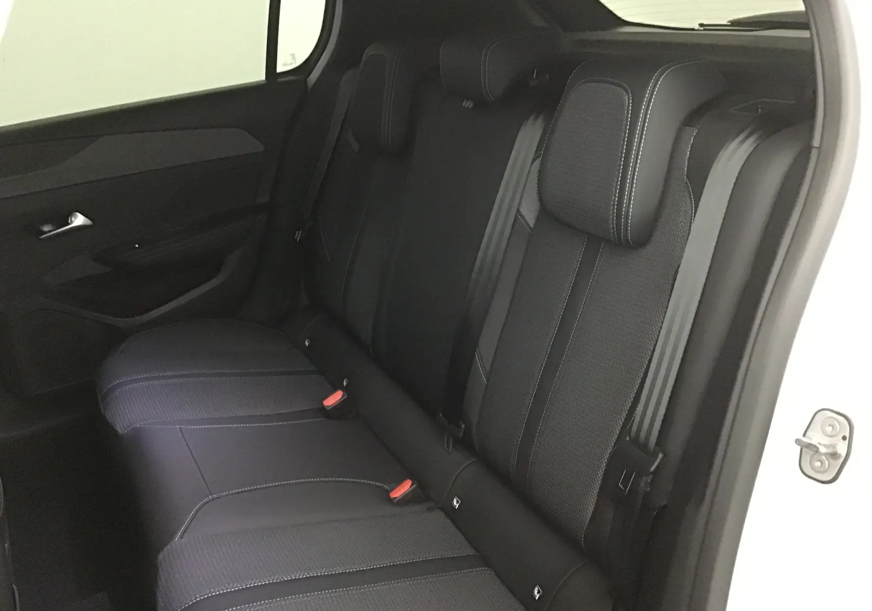 Vue intérieure côté gauche des sièges arrière noirs en tissu et cuir de la Peugeot 308 2025 gris Sellenium.