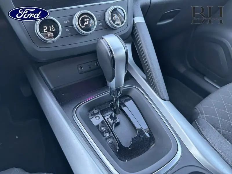 Gros plan sur le levier de vitesses automatique noir et argent dans l'habitacle du Renault Kadjar noir étoilé, côté droit.