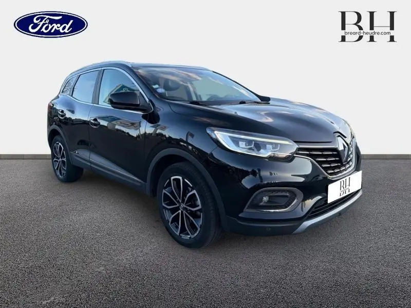 Renault Kadjar noir étoilé en 3/4 avant droit, avec jantes alliage et calandre chromée visible.