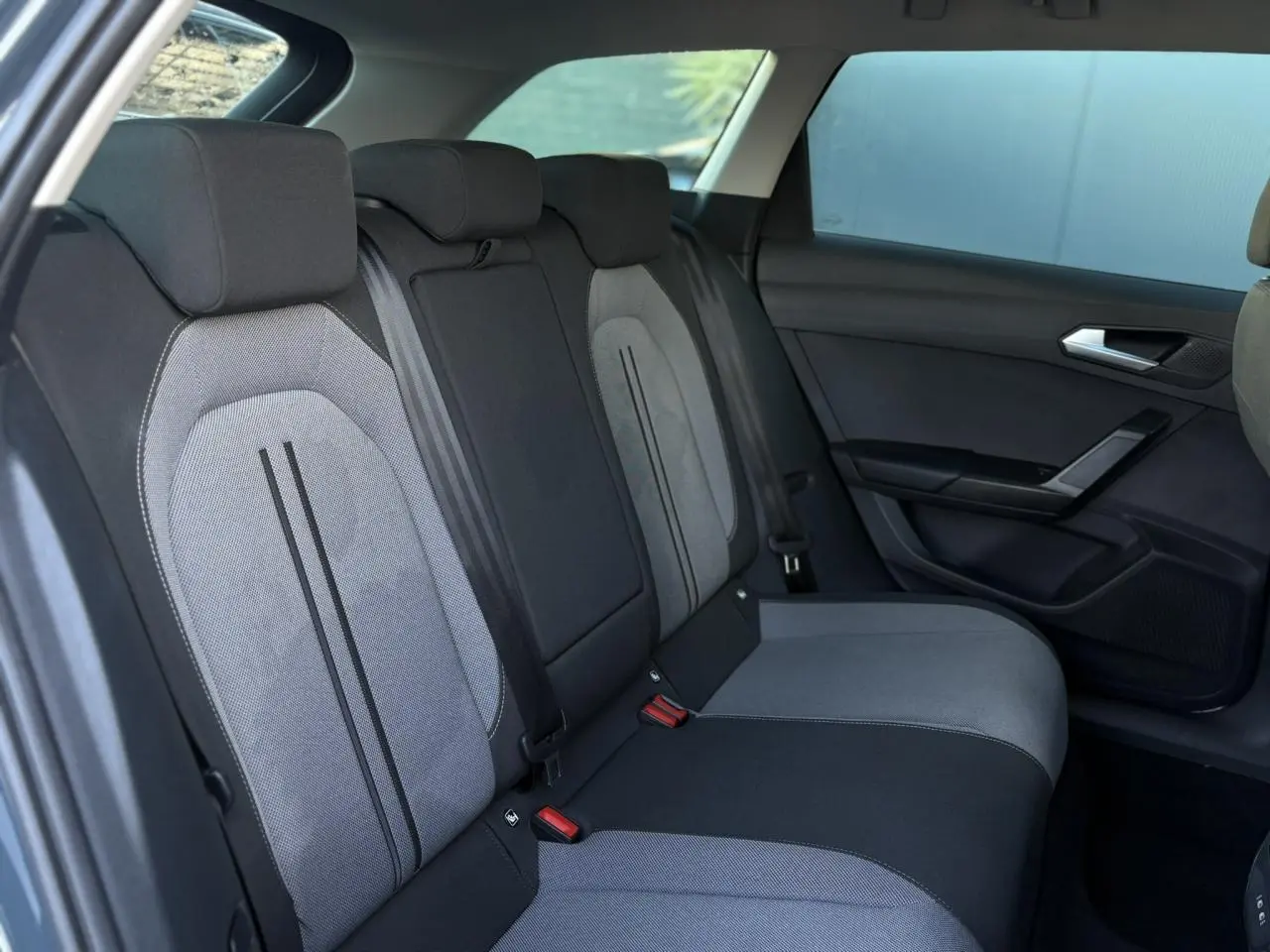 Vue latérale droite des sièges arrière bi-ton gris et noir du SEAT LEON ST 2.0 TDI 115 Style 2025 avec ceinture de sécurité visible.