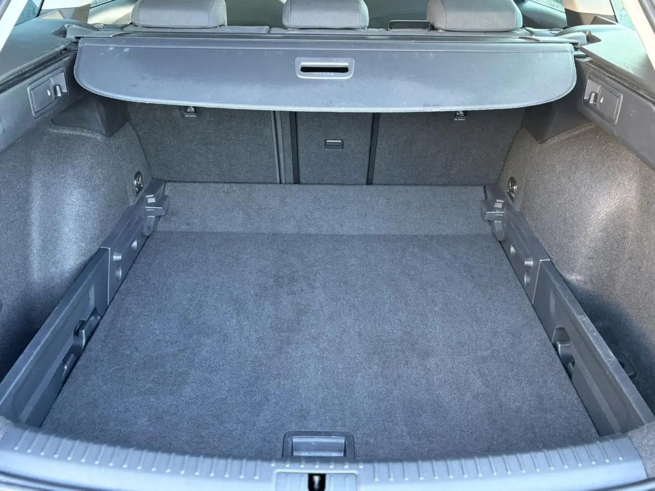 Vue plongeante sur le coffre spacieux et vide du SEAT LEON ST 2.0 TDI 115 Style, intérieur gris foncé.