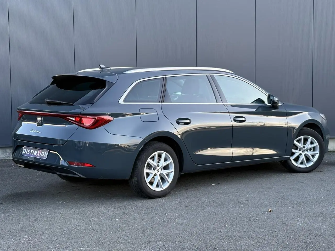 Vue 3/4 arrière droite d'une SEAT Leon ST 2025 bleu Fjord avec jantes alliage et vitres arrière surteintées.