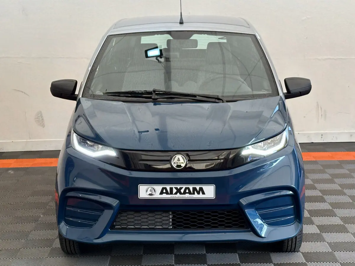 Vue frontale d'une Aixam Ambition 0.5 City Pack bleu 2026 avec phares LED et calandre noire brillante.