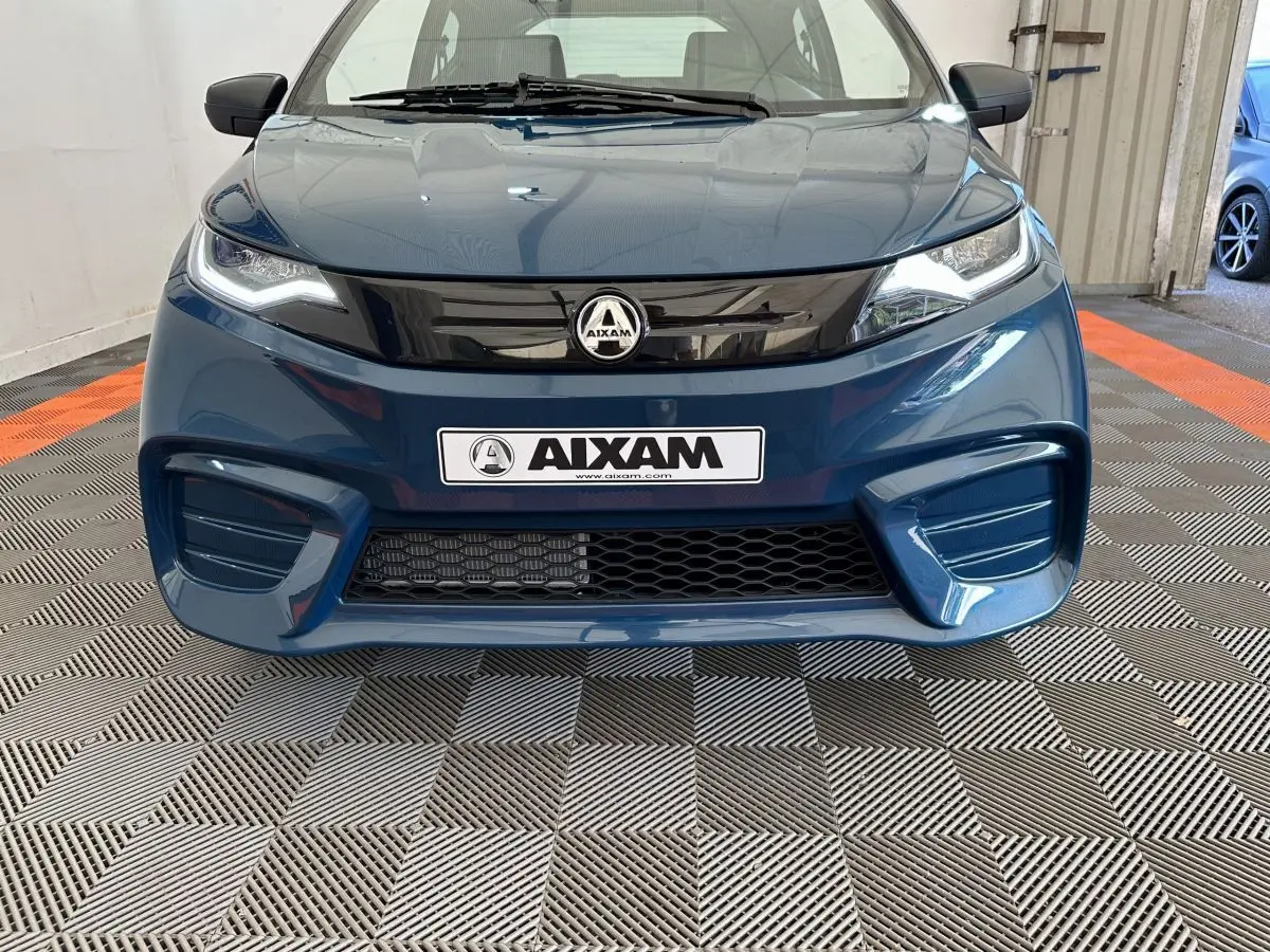 Vue frontale d'une Aixam Ambition 0.5 City Pack bleu 2026 avec calandre noire brillante et phares LED marqués.