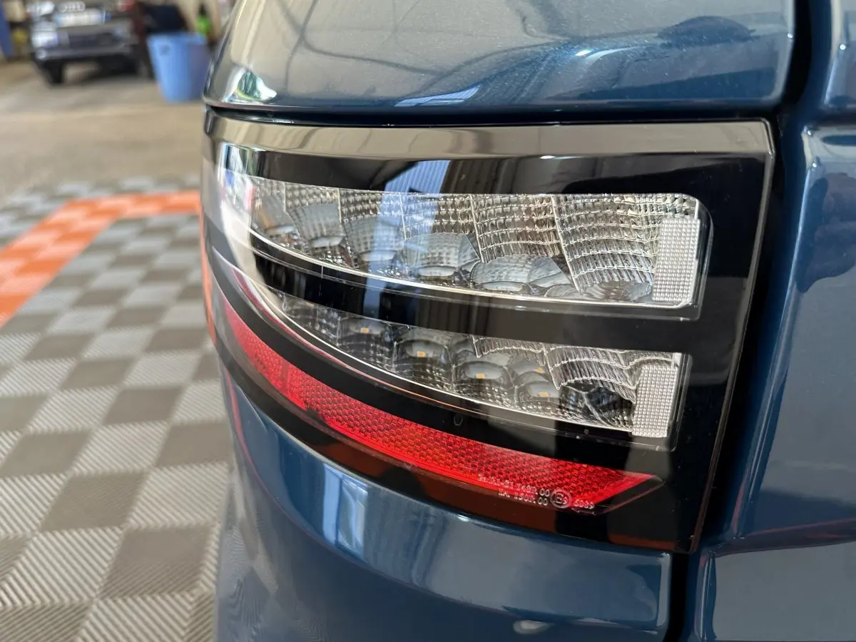 Gros plan sur le feu arrière droit bleu de l'AIXAM AMBITION 0.5 CITY PACK 2026 avec détails lumineux distinctifs.