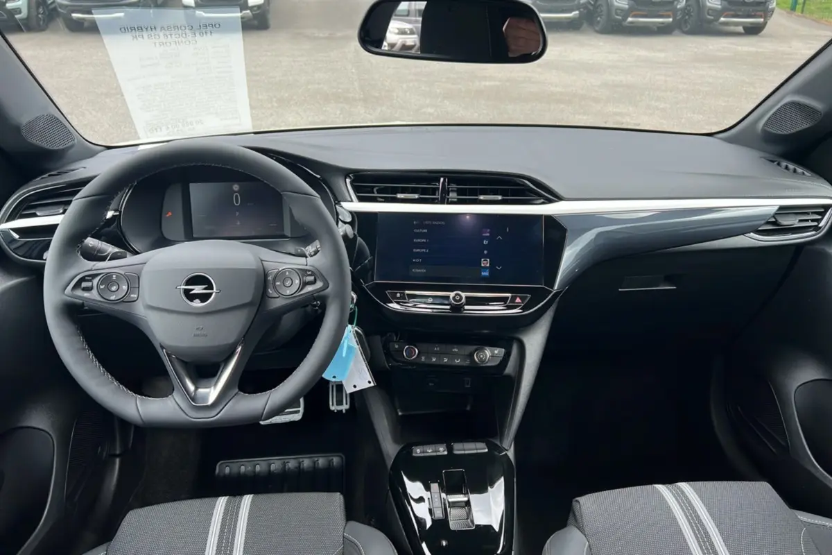 Vue intérieure avant de l’Opel Corsa Hybrid blanc Kontur, volant cuir multifonctions et écran tactile 10 pouces au centre.
