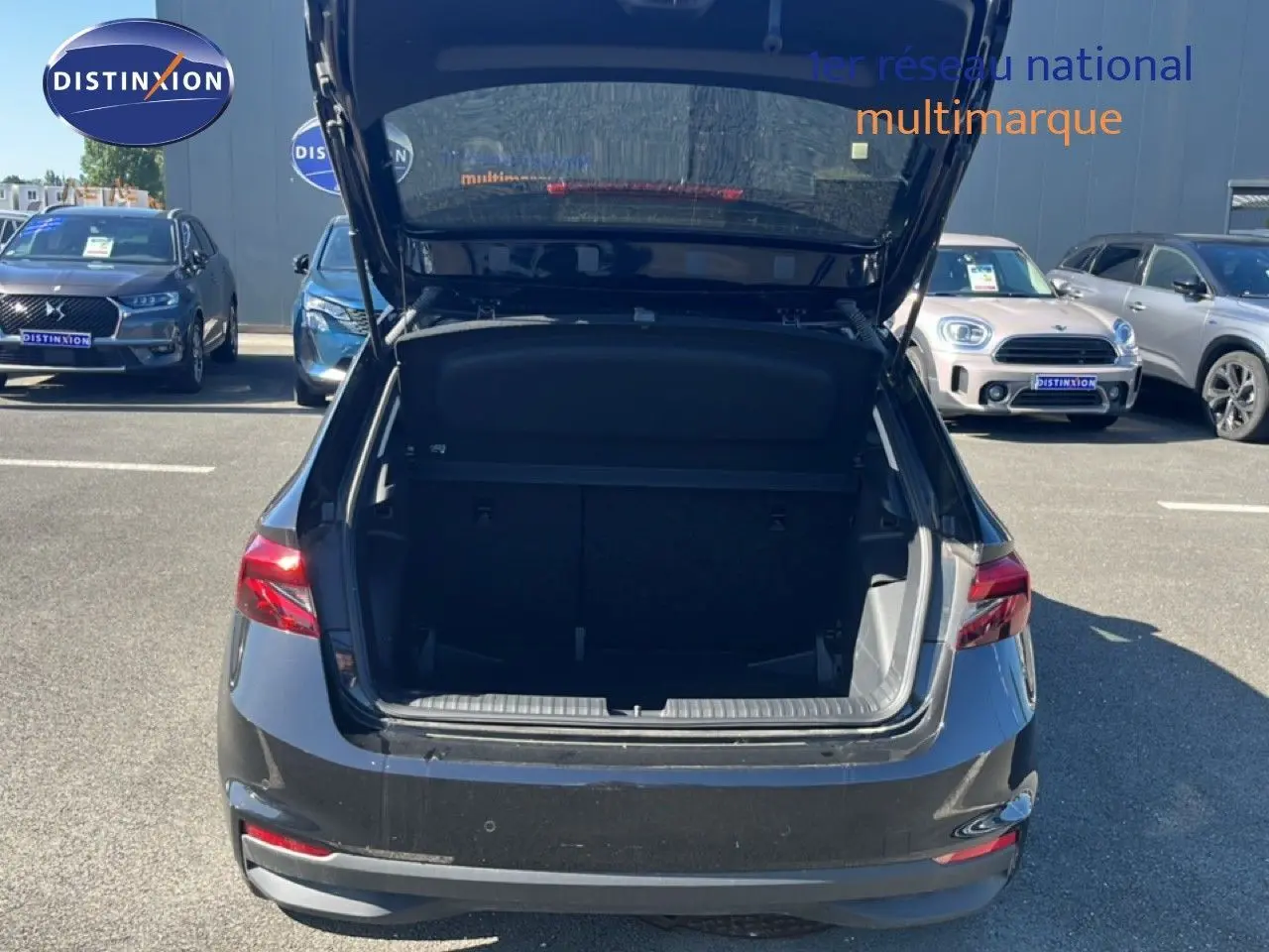 Vue arrière d'une Skoda Fabia noire avec le coffre ouvert, montrant l'espace de chargement vide en extérieur.