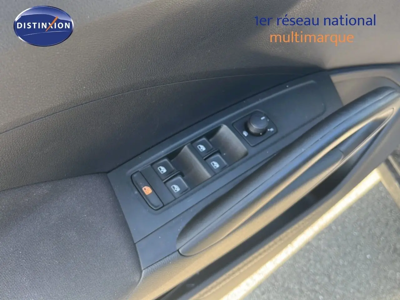 Détail de la commande des vitres électriques sur la portière avant gauche d'une Skoda Fabia noire.