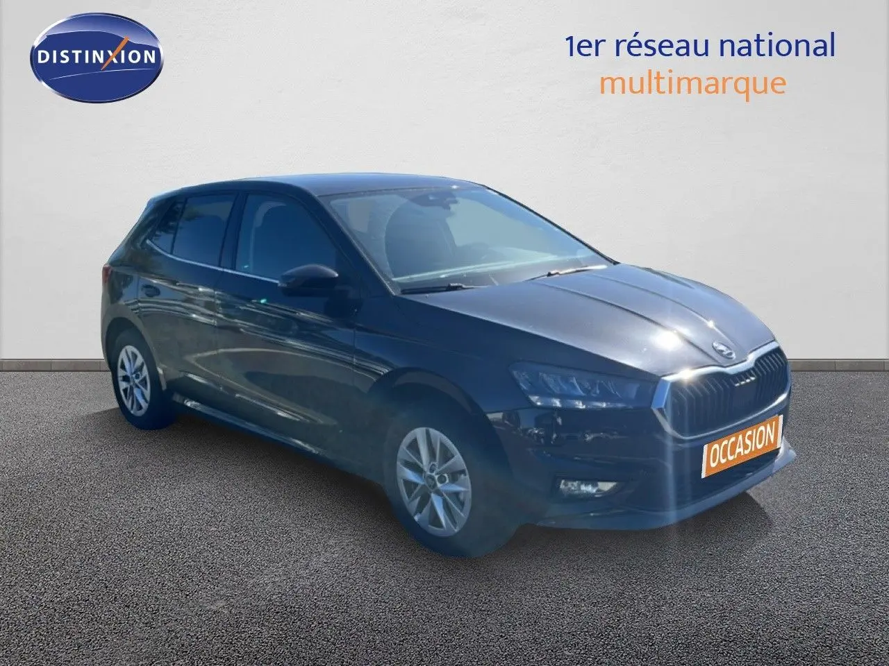 Vue 3/4 avant d’une Skoda Fabia noire métallisée avec jantes alliage et plaque « Occasion » visible.