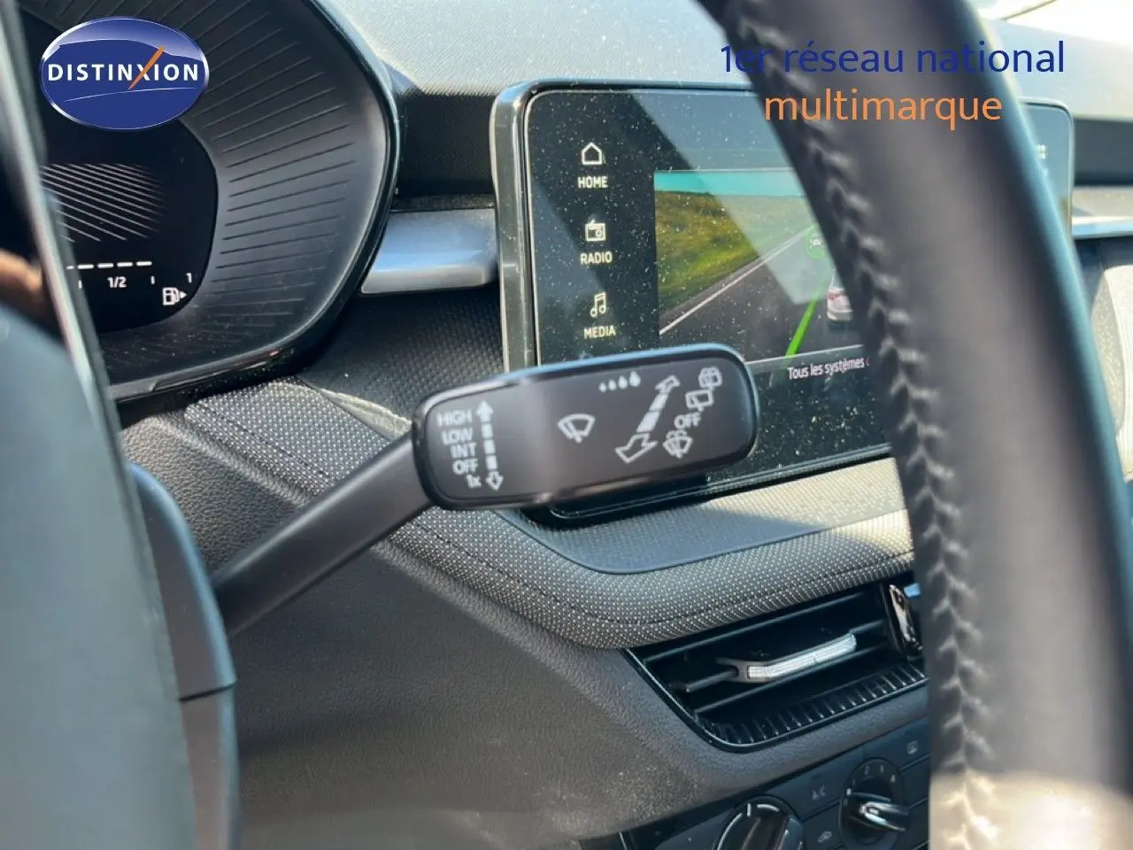 Gros plan sur la commande d’essuie-glace et l’écran tactile du tableau de bord intérieur d’une Skoda Fabia noire.