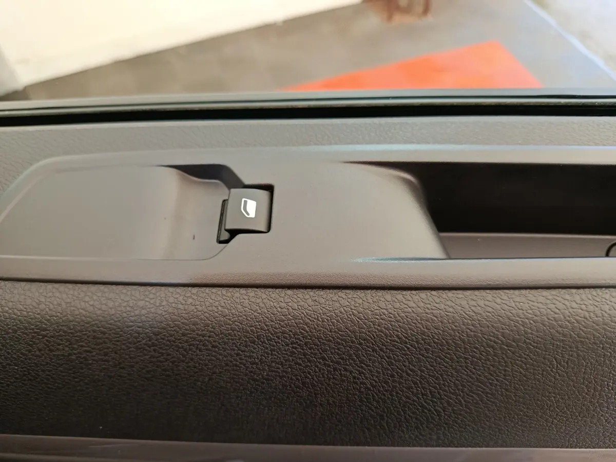 Détail de la commande de lève-vitre sur la porte intérieure d’un Peugeot Expert Fourgon noir, vue rapprochée.