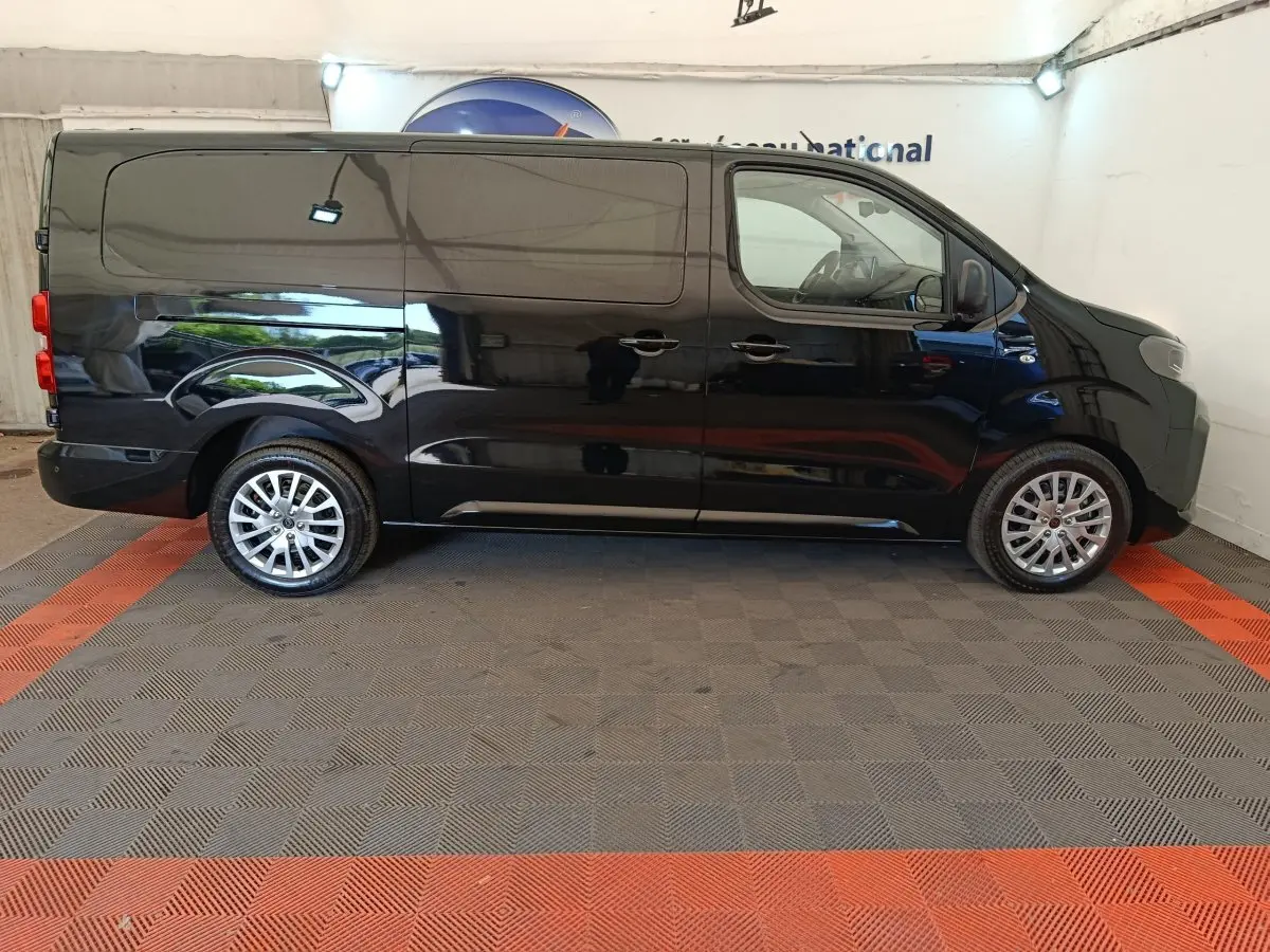 Vue latérale droite d’un Peugeot Expert Fourgon XL noir, avec roues alliage et porte latérale coulissante visible.