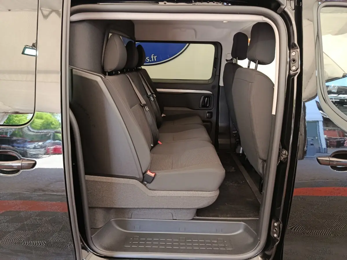 Vue latérale intérieure du Peugeot Expert Fourgon XL noir, montrant la banquette arrière 3 places et les portes coulissantes ouvertes.