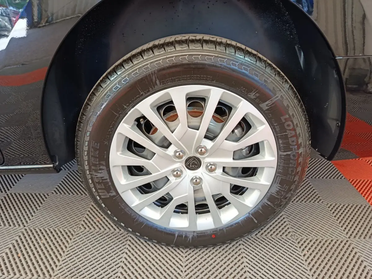 Gros plan sur la roue avant droite du Peugeot Expert Fourgon noir, avec jante argentée et logo Peugeot central.