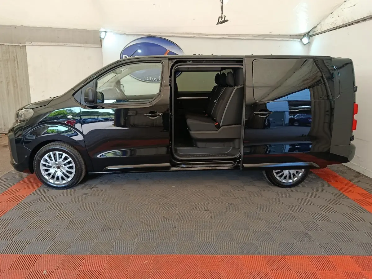 Vue latérale gauche d’un Peugeot Expert Fourgon XL noir avec porte coulissante ouverte révélant la banquette arrière trois places.