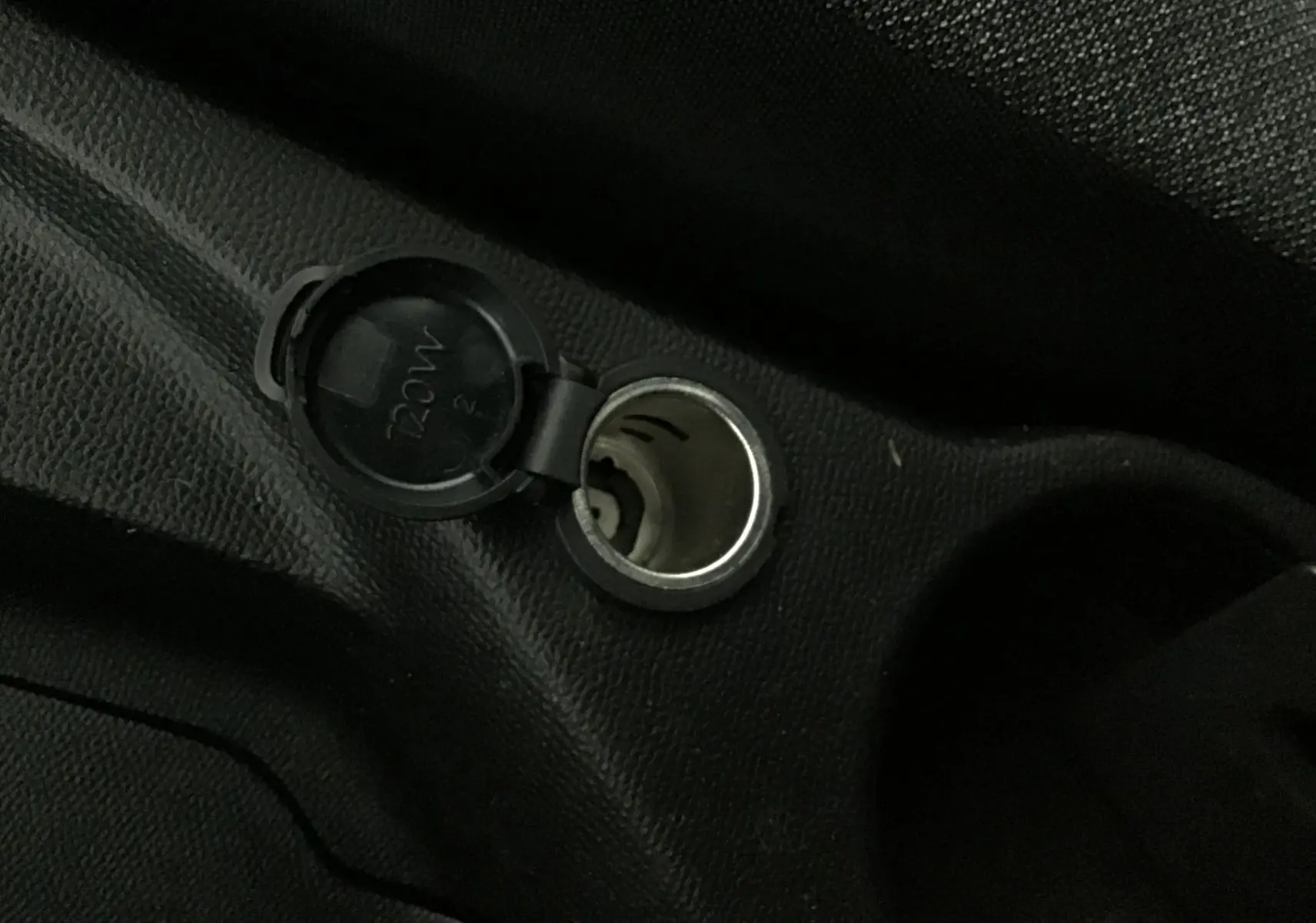 Prise 12V ouverte sur la console centrale intérieure d'une Peugeot 208 noire, version 1.2 PureTech 100 Style GPS S&S.