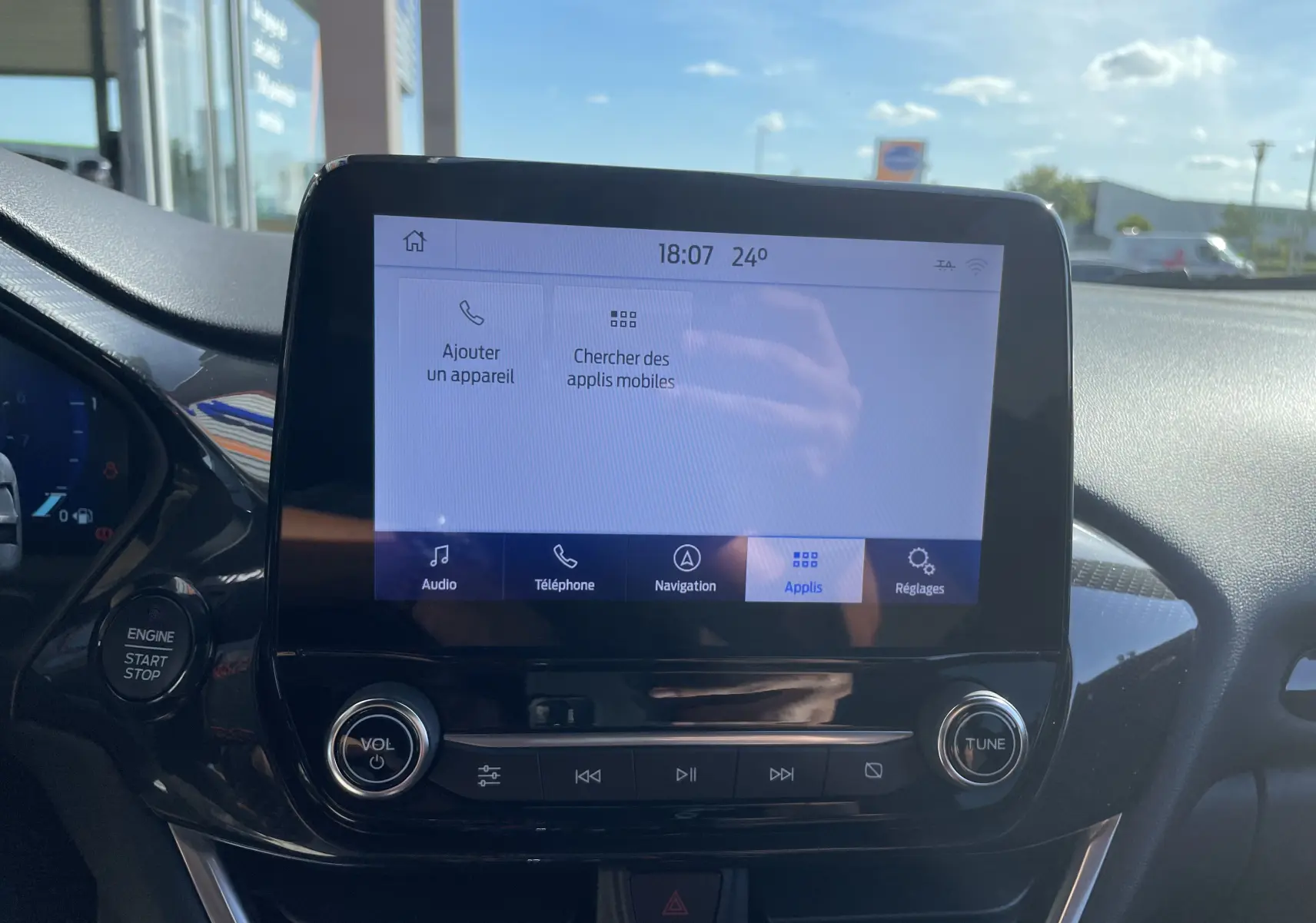 Écran tactile central du tableau de bord du Ford Puma 2021, affichant le menu des applications avec commandes audio et bouton start/stop.