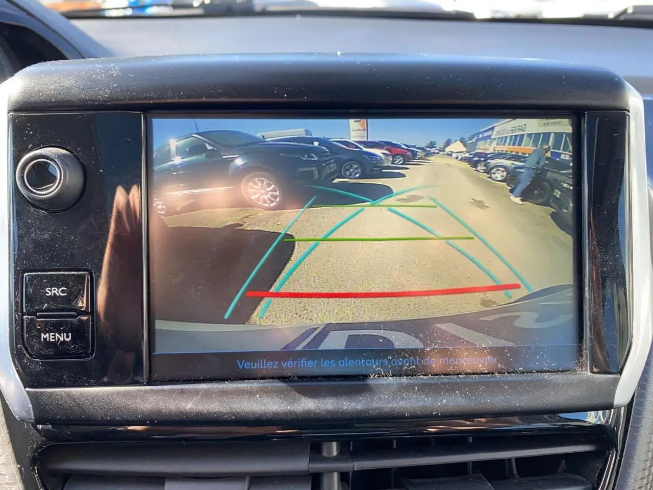 Vue de la caméra de recul du Peugeot 2008 2019 montrant une rangée de voitures sur un parking en arrière-plan.