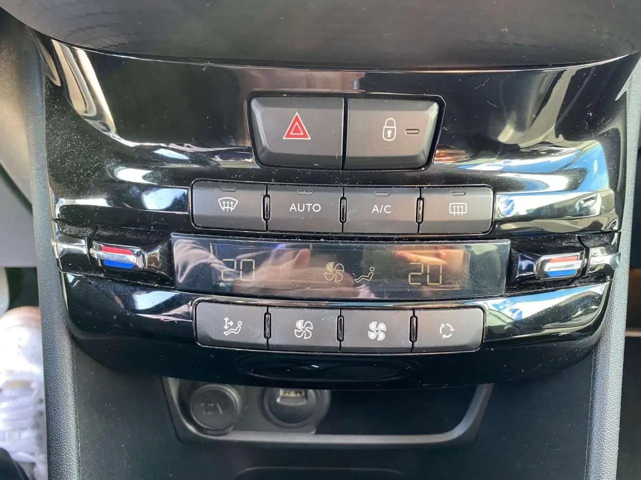 Vue rapprochée de la console centrale noire du Peugeot 2008 2019 avec commandes climatisation automatique bi-zone.