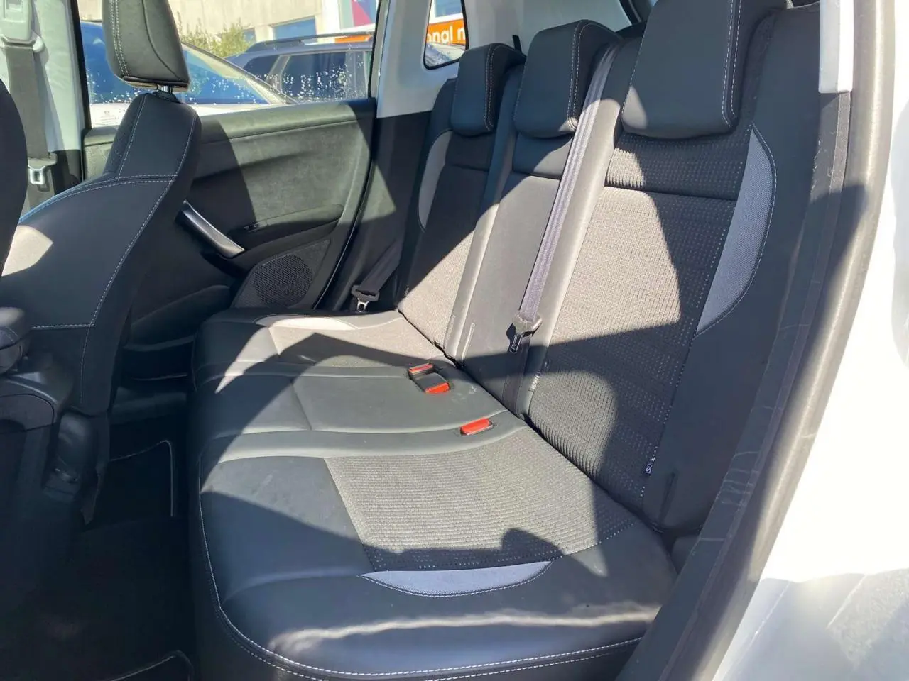 Vue latérale des sièges arrière en tissu noir et gris du Peugeot 2008 2019, porte arrière ouverte.