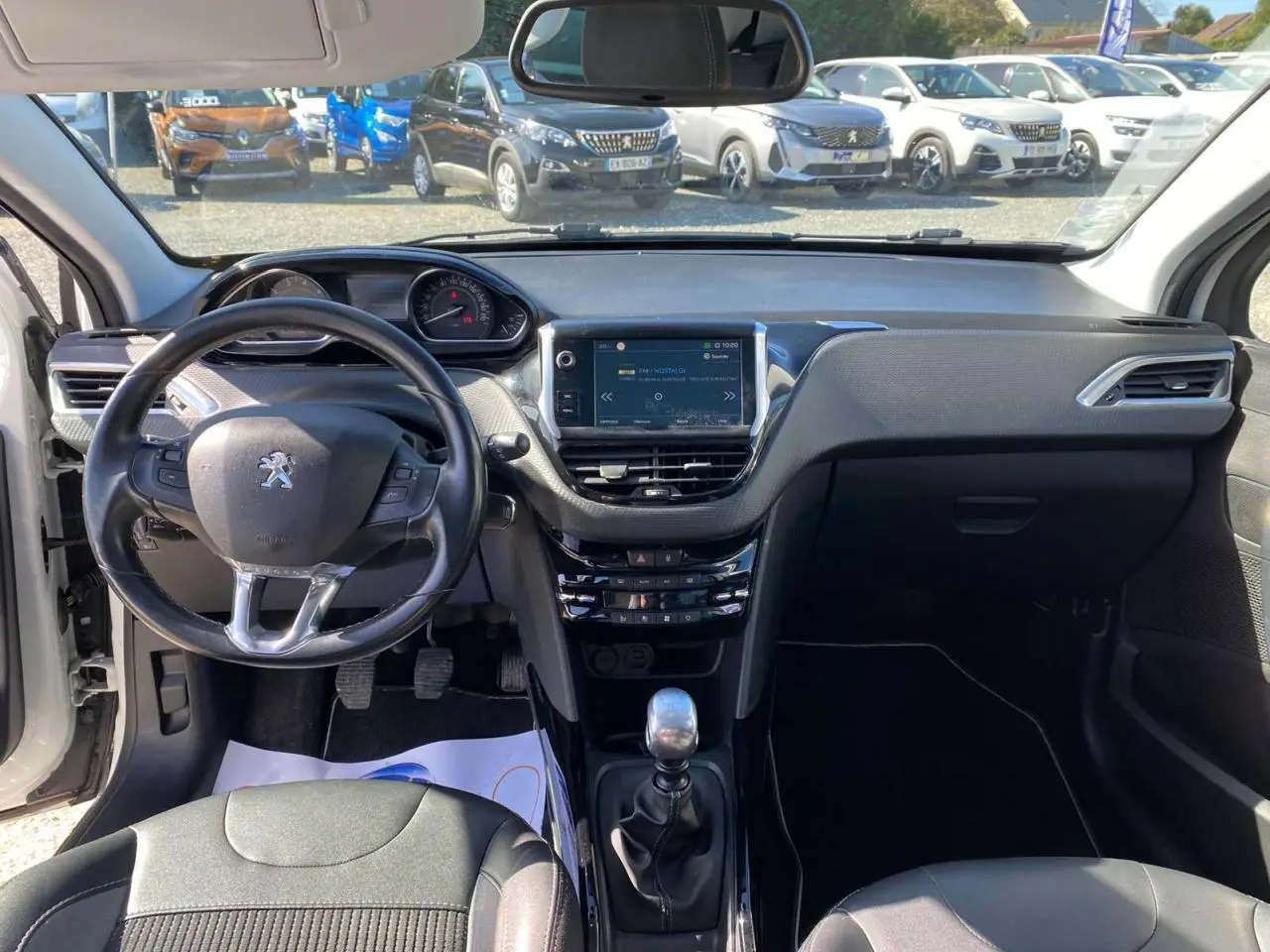 Vue intérieure avant du tableau de bord et volant cuir de la Peugeot 2008 1.2i 12V S&S 130 Allure avec écran tactile central.