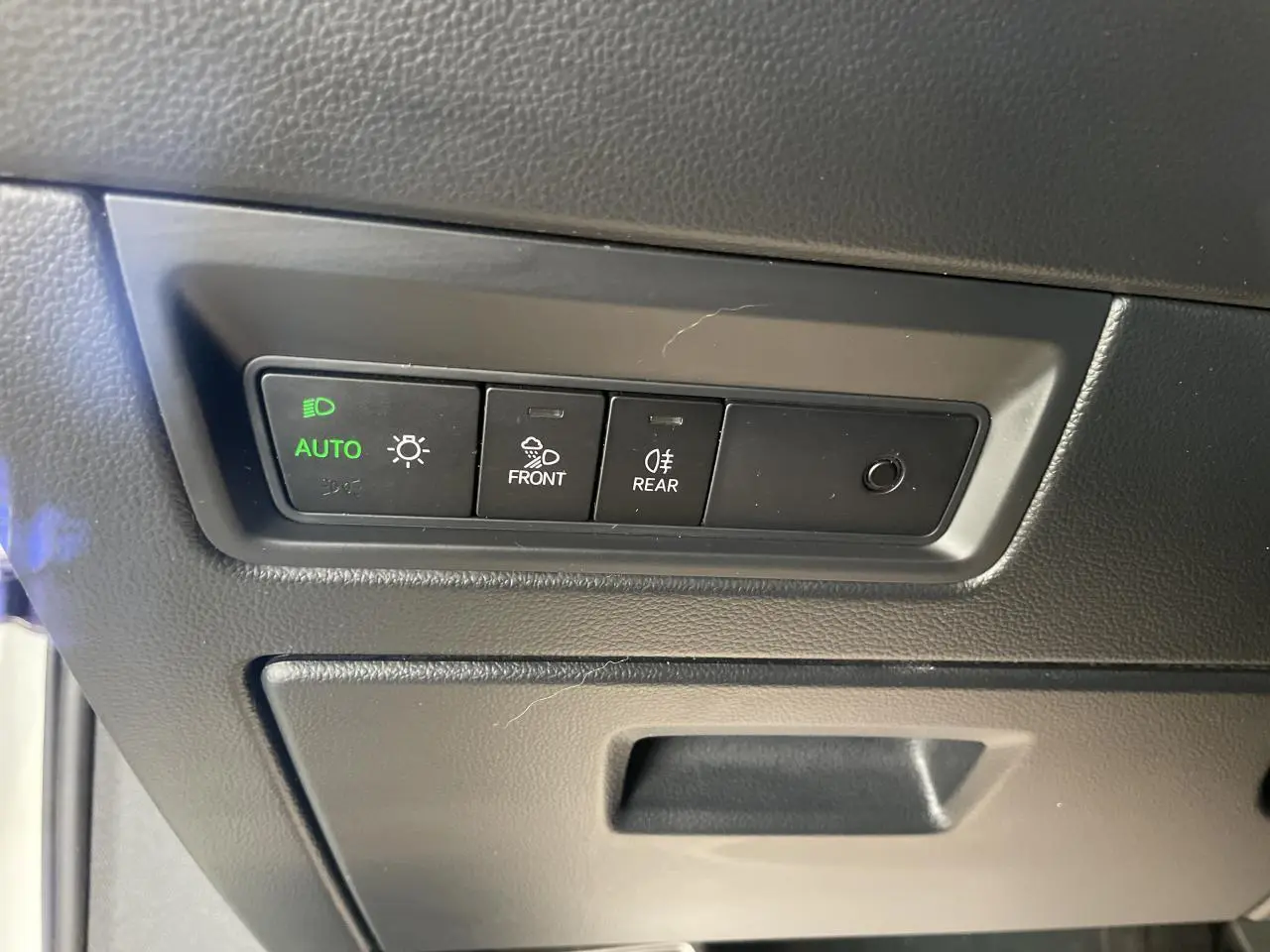 Panneau de commandes des feux avec mode automatique allumé dans un Volkswagen Touareg blanc, vue intérieure.