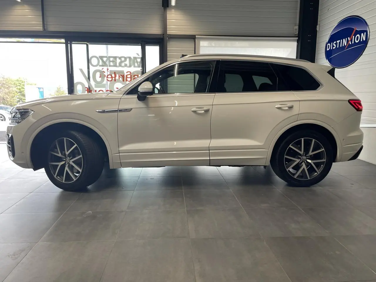 Profil côté gauche d'un Volkswagen Touareg blanc 2019 avec jantes alliage 20 pouces et vitres teintées.