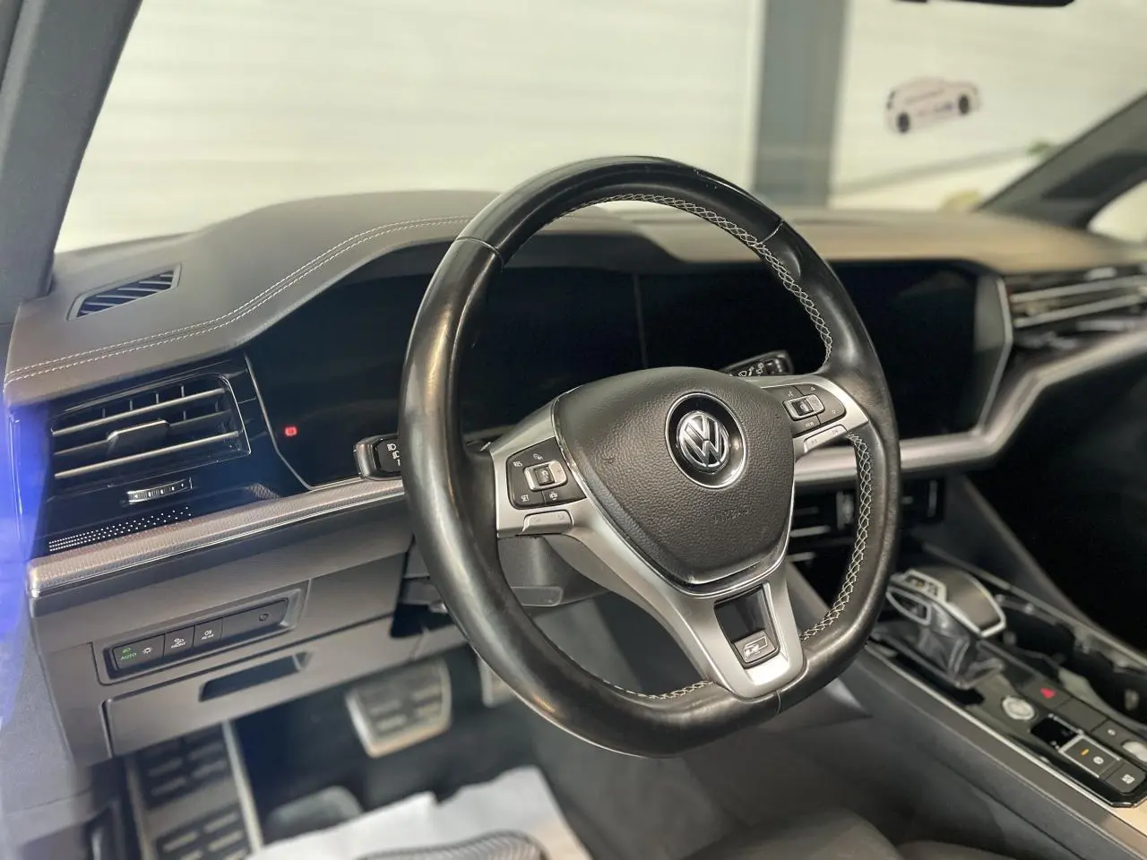 Volant cuir noir avec surpiqûres blanches de Volkswagen Touareg 2019, vue intérieure côté conducteur.
