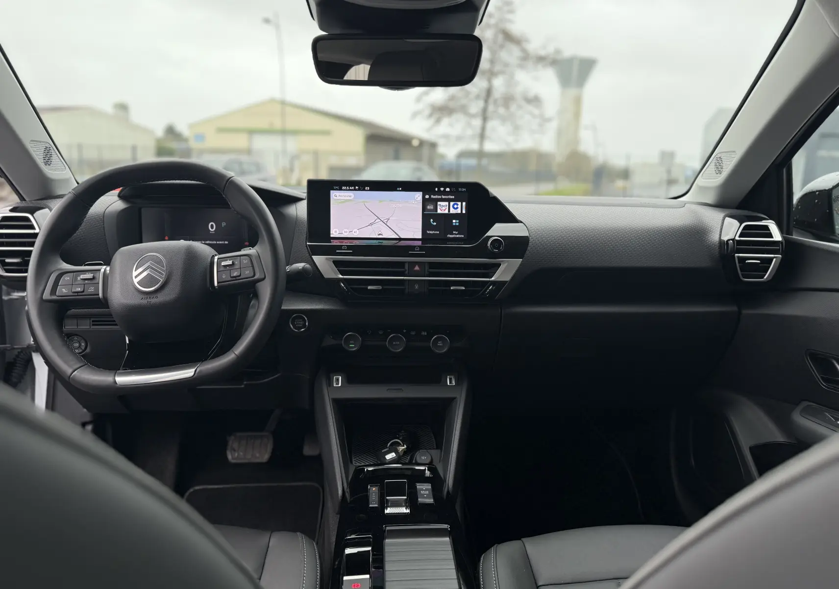 Vue intérieure frontale du tableau de bord et volant noir du Citroën C4 Hybrid 145 e-DCS6 Max 2025.